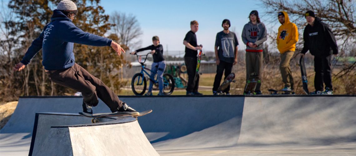 A person skates on a ramp.